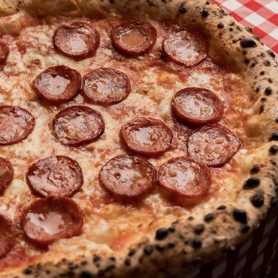 a close up shot of shiny pepperoni pizza