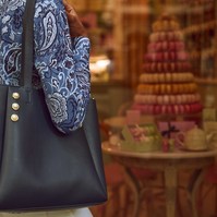  Woman with stylish handbag standing in front of French patisserie display with macarons — Melbourne fashion and lifestyle photography