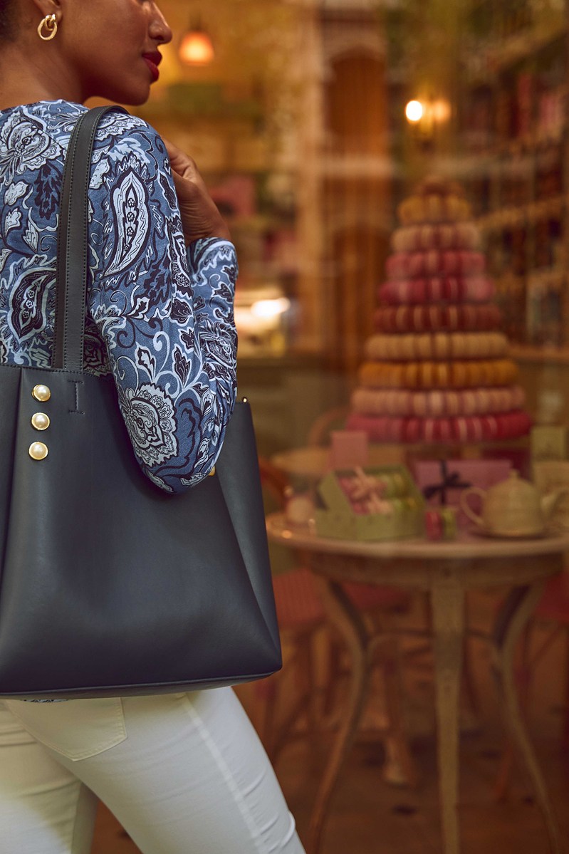  Woman with stylish handbag standing in front of French patisserie display with macarons — Melbourne fashion and lifestyle photography