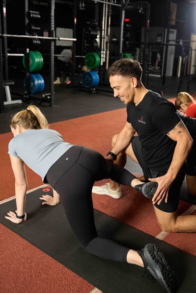 a trainer showing the gym member how to do exercise