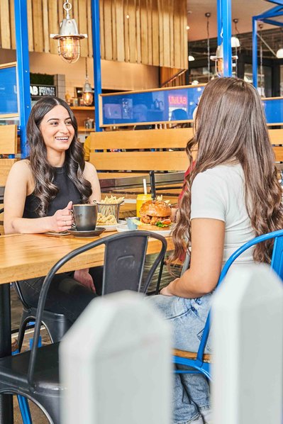 two girls sitting in a cafe enjoying brunch