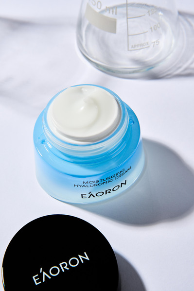 a face cream in a blue packaging lying on a white background with shadows