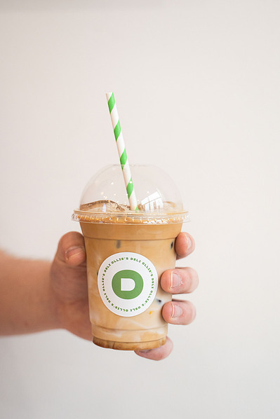 a hand holding an iced coffee
