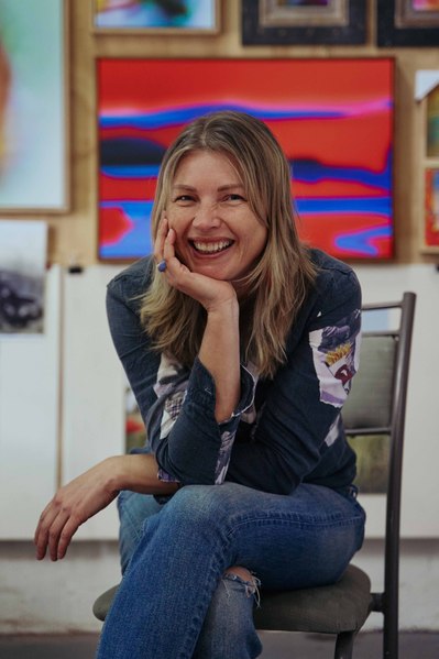 artist in her studio looking at the camera smiling