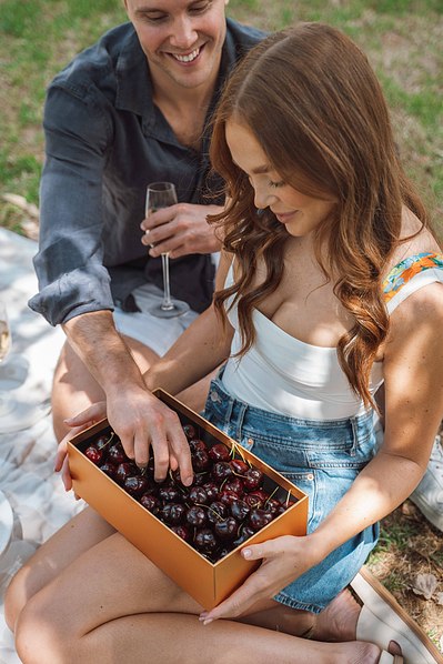 a man getting cherries from the box from a girl - St Kilda lifestyle photographer by Marcie Raw 