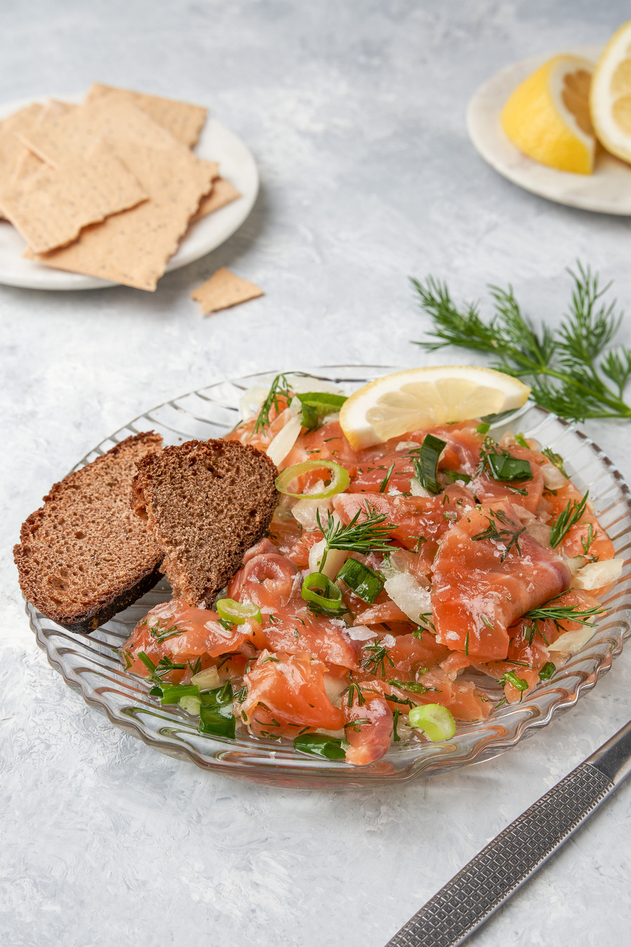 salmon with lemon and parsley on a plate on a white table