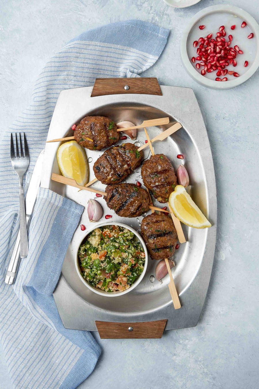 lamp chops on a long plate with a blue napkin under it