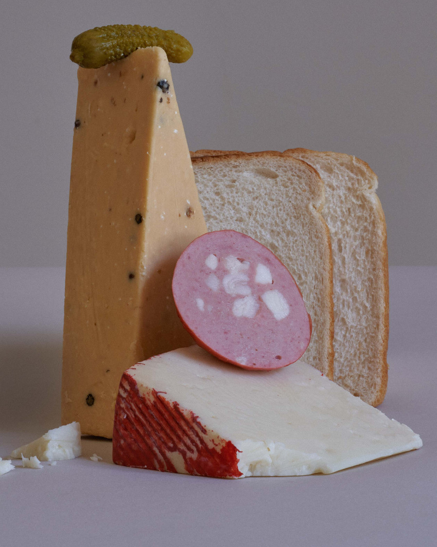 a few pieces of cheese and sausages on top of one another
