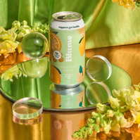 Product photo of stacked drink cans on a reflective surface with flowers and crystals — Melbourne product photographer