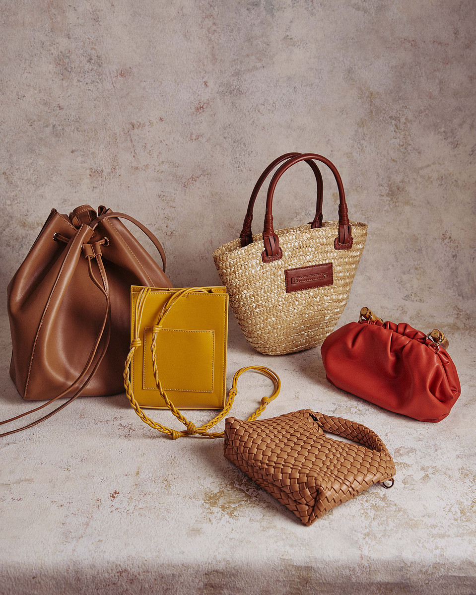 Flatlay of designer handbags and woven tote by Marcie Raw, Melbourne product and fashion photographer