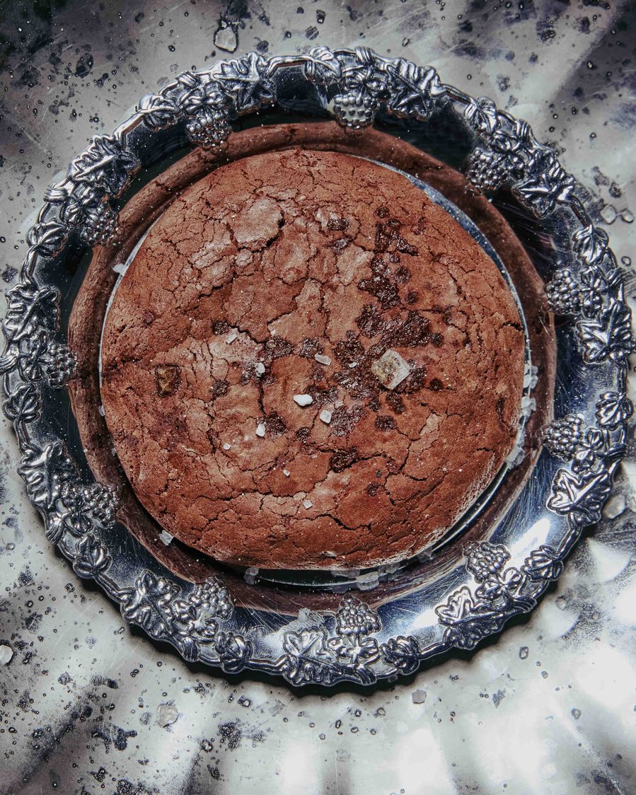 Rich chocolate tart on a textured ceramic plate with a dramatic light and shadow setup