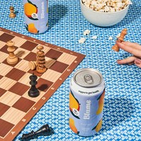Colourful flatlay of fruit soda cans with popcorn and chess board by Marcie Raw, Melbourne product photographer