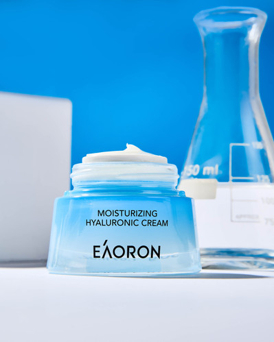 blue face cream on a white background with lab props in the background