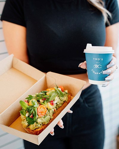 Two’s Company branded takeaway coffee cup held by customer – Melbourne café lifestyle photography by Marcie Raw