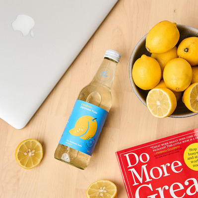 Creative flat lay of sparkling lemon drink, sliced lemons, and book – commercial food styling by Marcie Raw in Melbourne