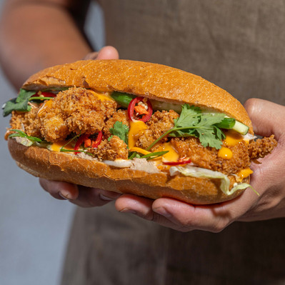 hands holding a styled banh mi 