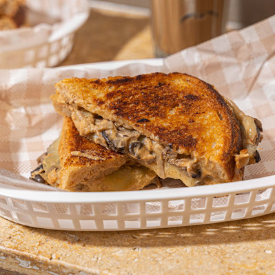 a melted mushroom and cheese sandwich cut in half 