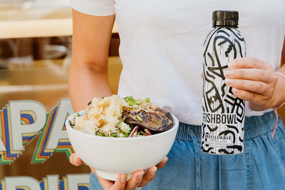 Person holding a branded salad bowl and Fishbowl water bottle outside a Melbourne eatery