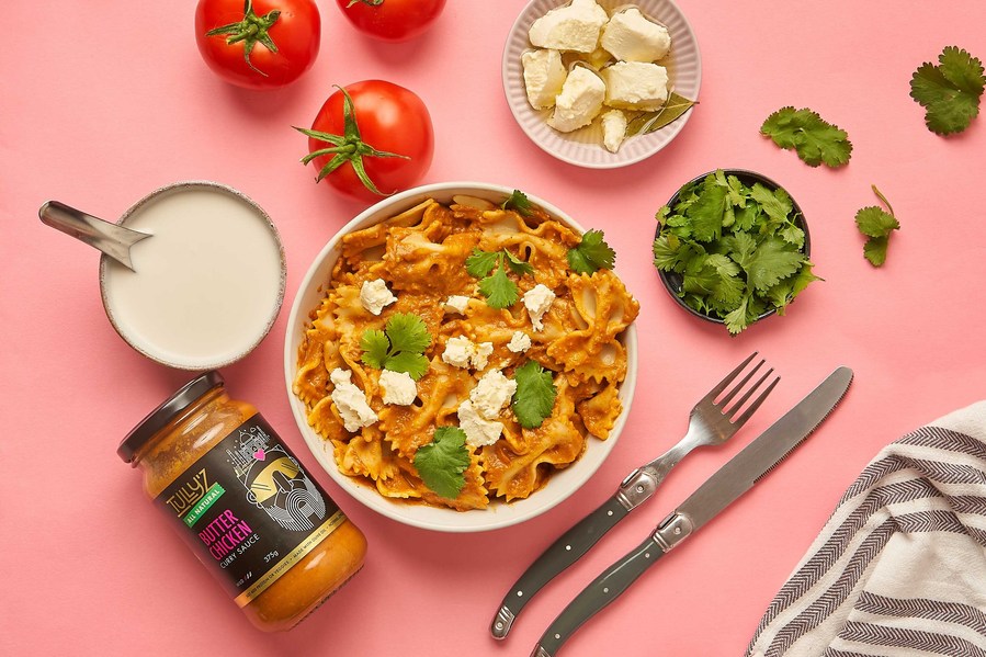 Indian curry with fresh ingredients lying around it