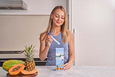 young girl in the kitchen taking the supplement powder from the box