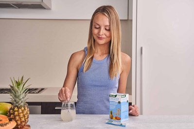 young girl in the kitchen stirring water in the glass