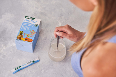 a hand stirring water with a supplement in it