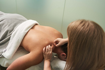 a hand putting a needle into patient's skin, acupuncture