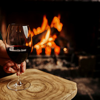 Glass of red wine by fireplace — lifestyle product photo Marcie Raw