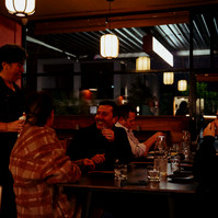 Group of friends dining at night in Melbourne restaurant by Marcie Raw, lifestyle photographer