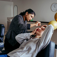 eye brow specialist styling client’s brows in modern salon with gold balloons — Melbourne lifestyle and small business photography.
