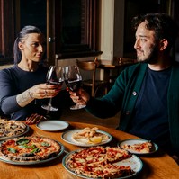 Couple dining with pizza and wine, captured by Marcie Raw, Melbourne lifestyle photographer