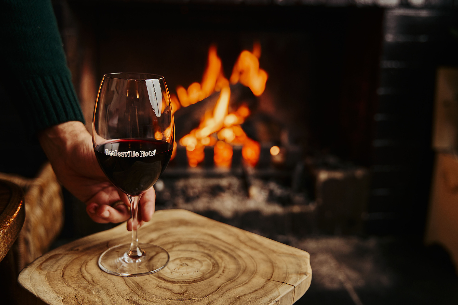 Glass of red wine by fireplace — lifestyle product photo Marcie Raw
