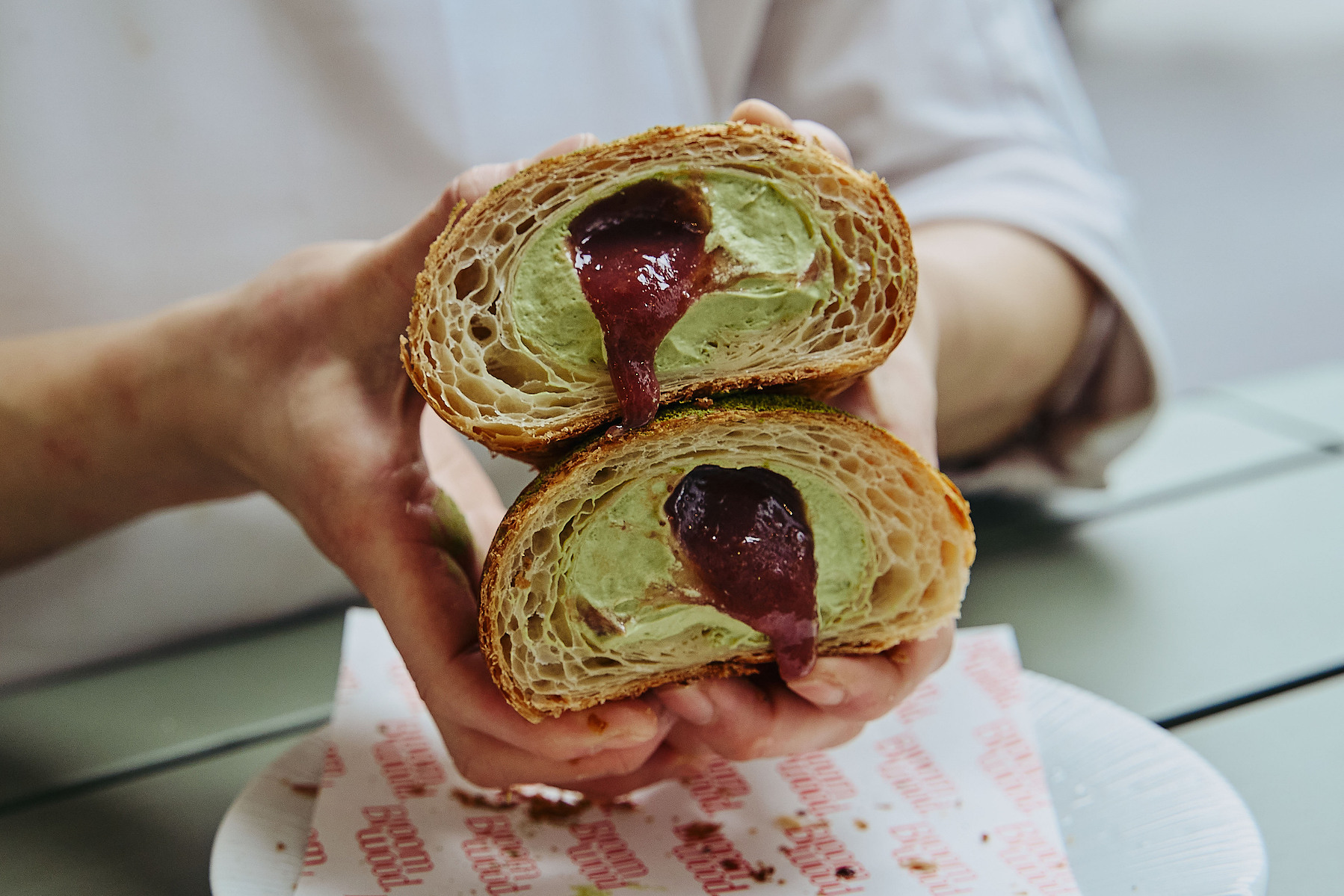 Hands holding pastry with jam filling — Melbourne food and café photography