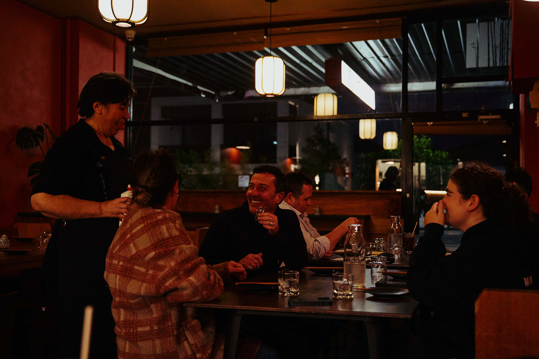 Group of friends dining at night in Melbourne restaurant by Marcie Raw, lifestyle photographer