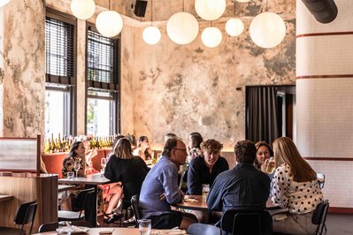 busy modern restaurant scene with people sitting at tables and enjoying the food