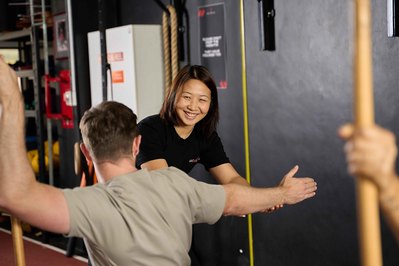 a trainer showing the gym member how to correctly do the exercise