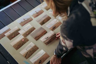 artist in the studio looking at the photos on the desk 