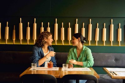 two friends talking and drinking cocktails in a restaurant 
