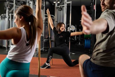 a group of people exercising in the gym with a trainer