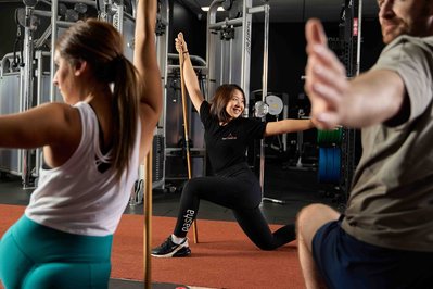 a group of people exercising in the gym with a trainer