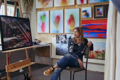 artist in her studio looking at a big print 