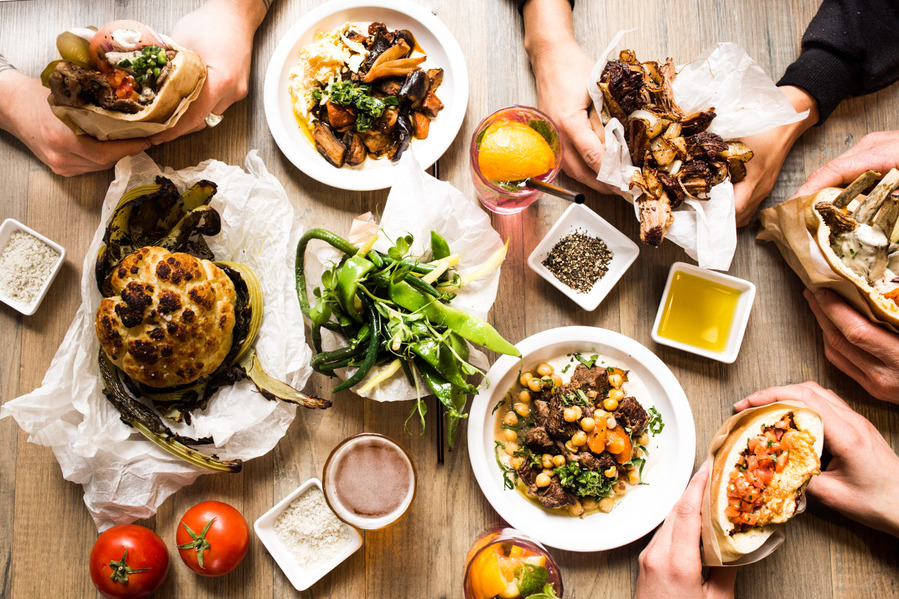 middle eastern food spread with roasted cauliflower, eggplant and pitas