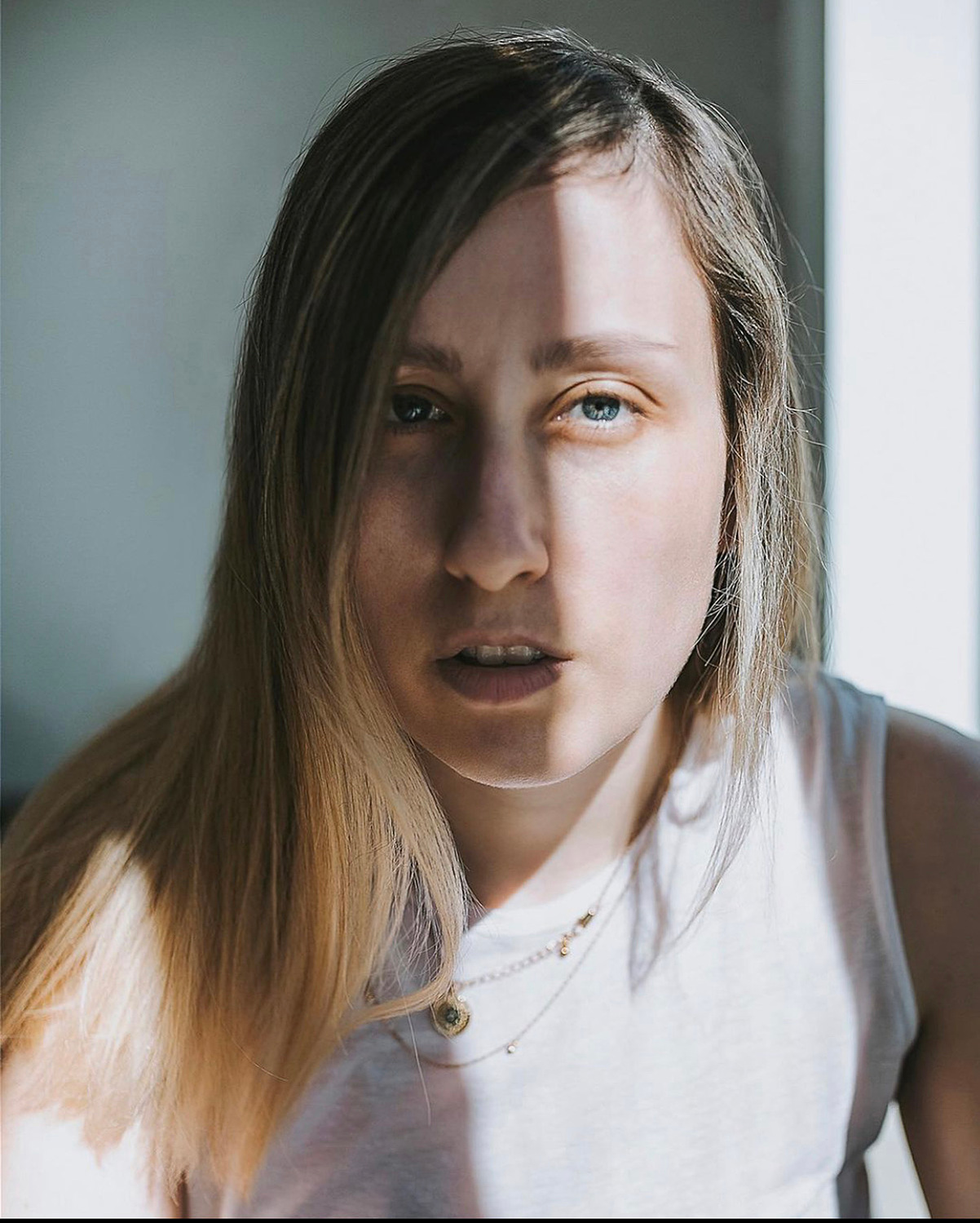 photo of Georgie Glass with half of face in shadow. Photography by Georgie Glass, Manchester