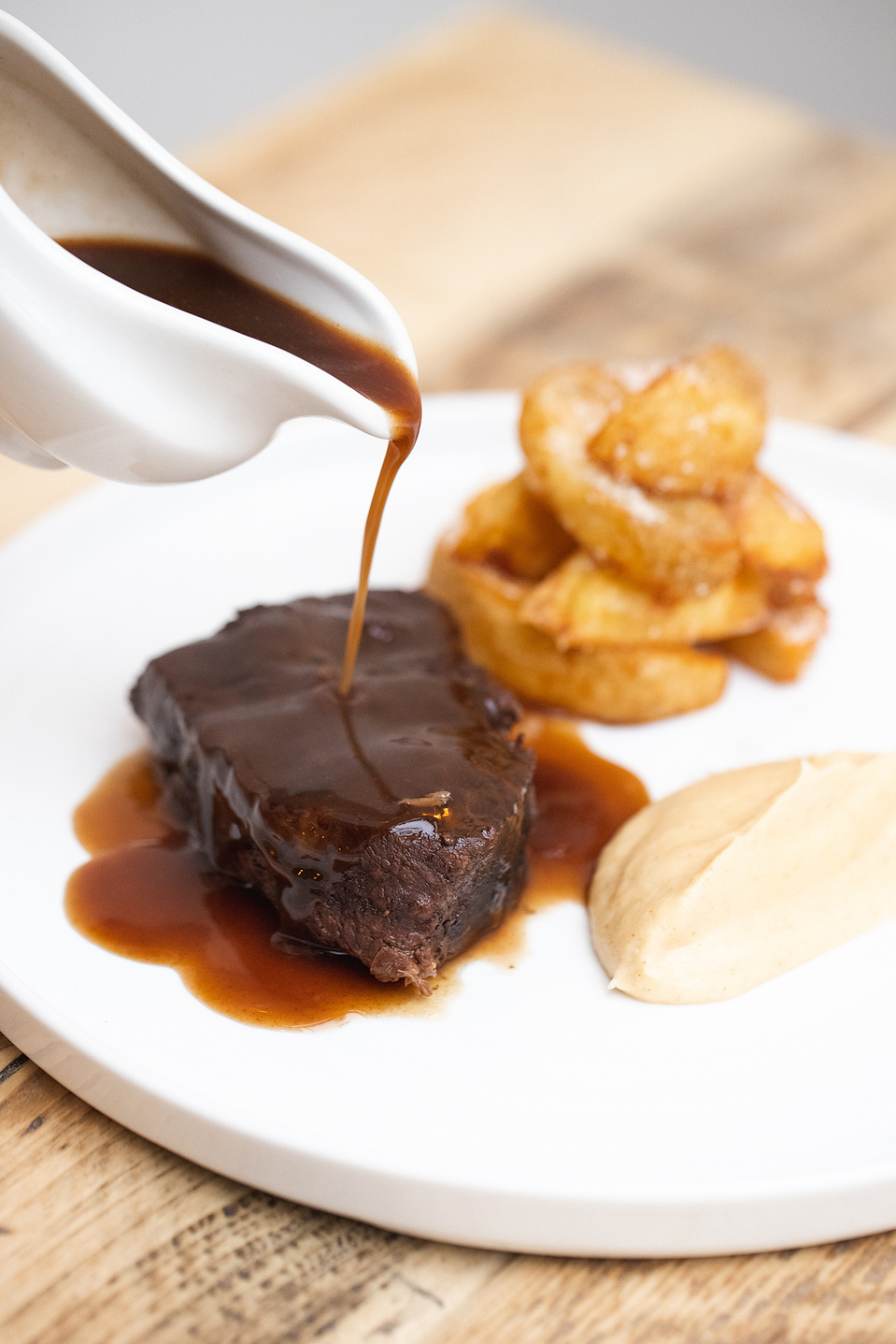 Georgie Glass Photography, food photographer, Manchester food photographer, The Wild Goose, gravy being poured on a feather-blade of beef, with creamed cauliflower and potatoes