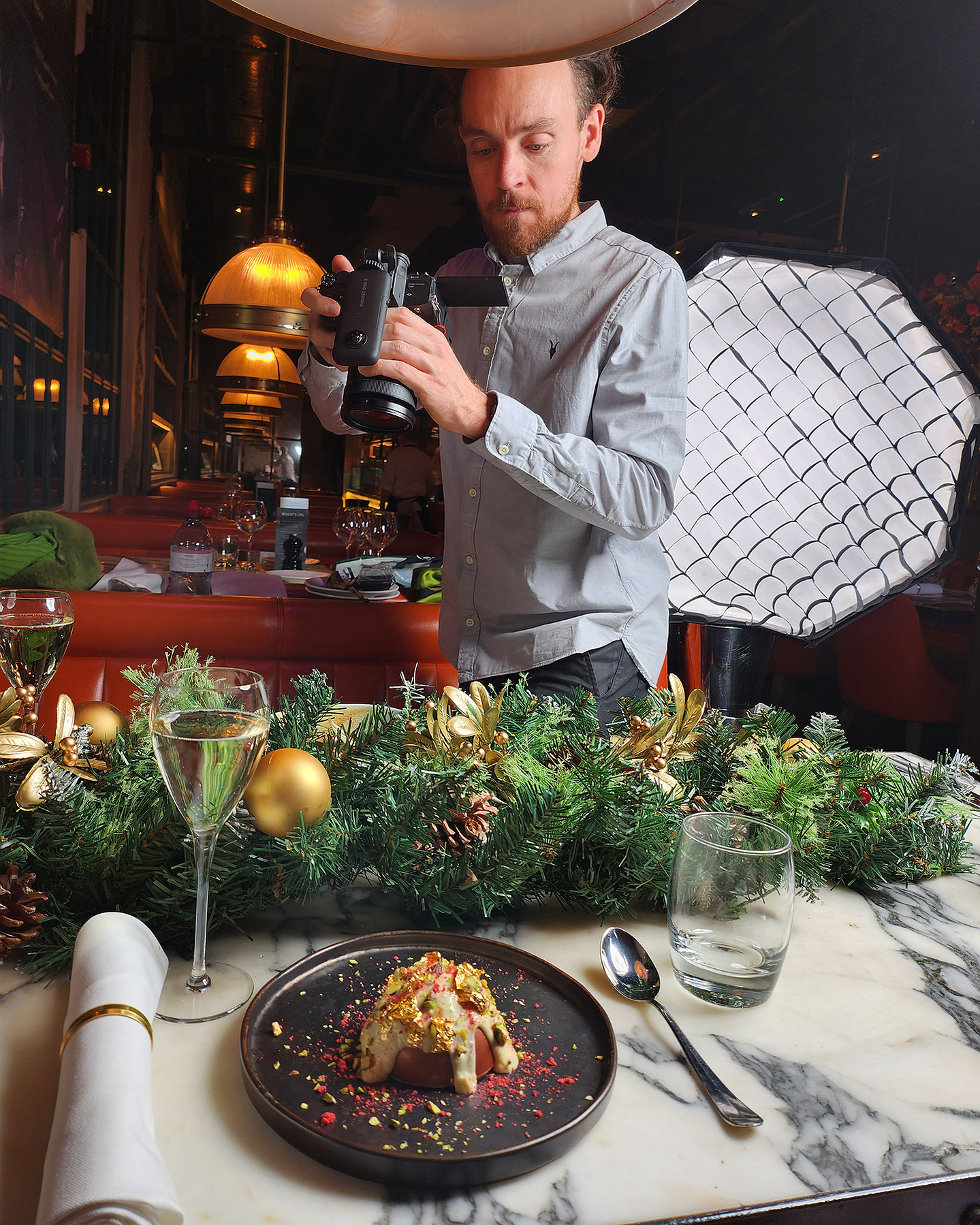 Man holding a video camera shooting the food on a christmas dining table photography by Georgie Glass Photography Manchester