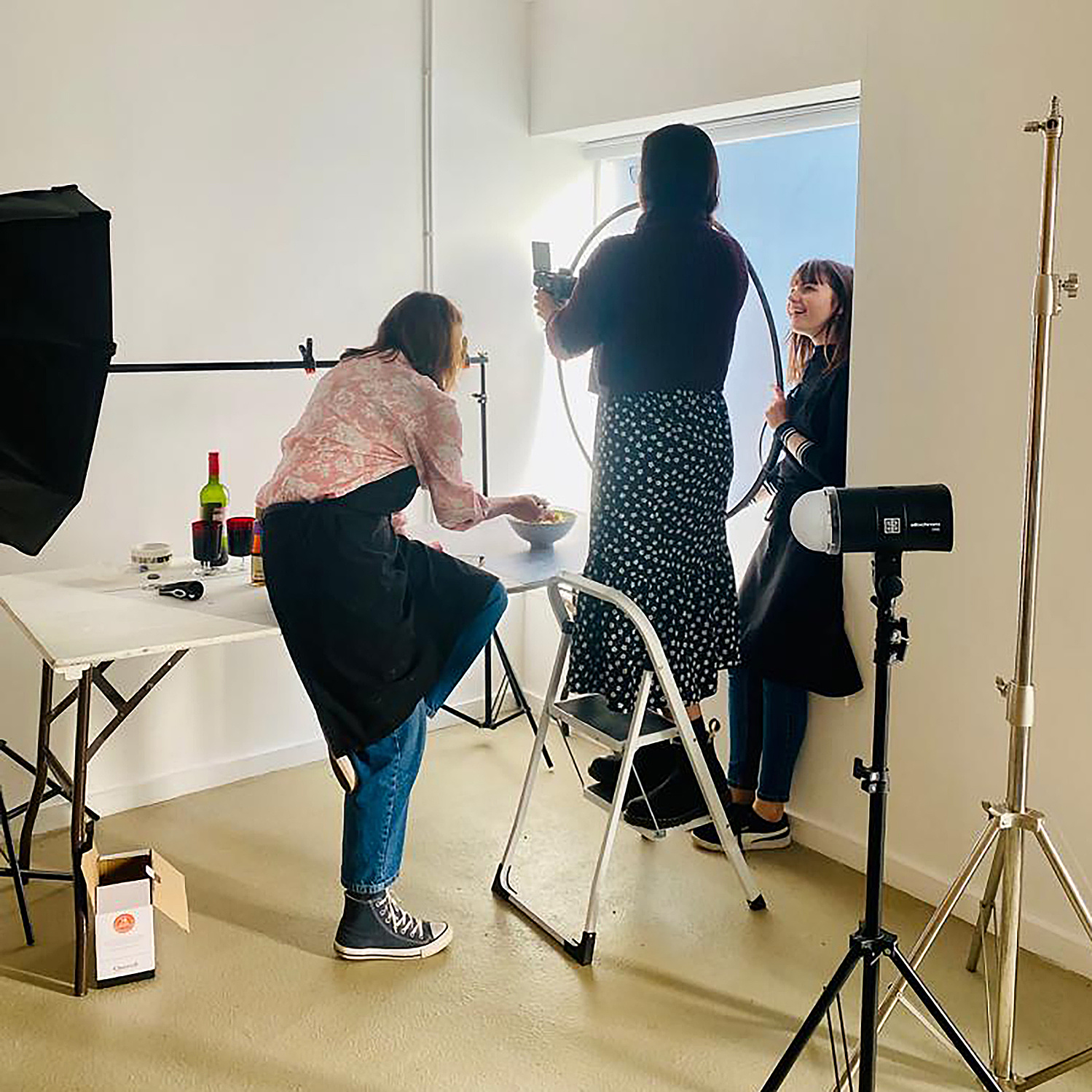 Georgie Glass working behind the scenes with a food stylist at a food photo shoot for Scott Baptie's 'High Protein Handbook' cookbook.