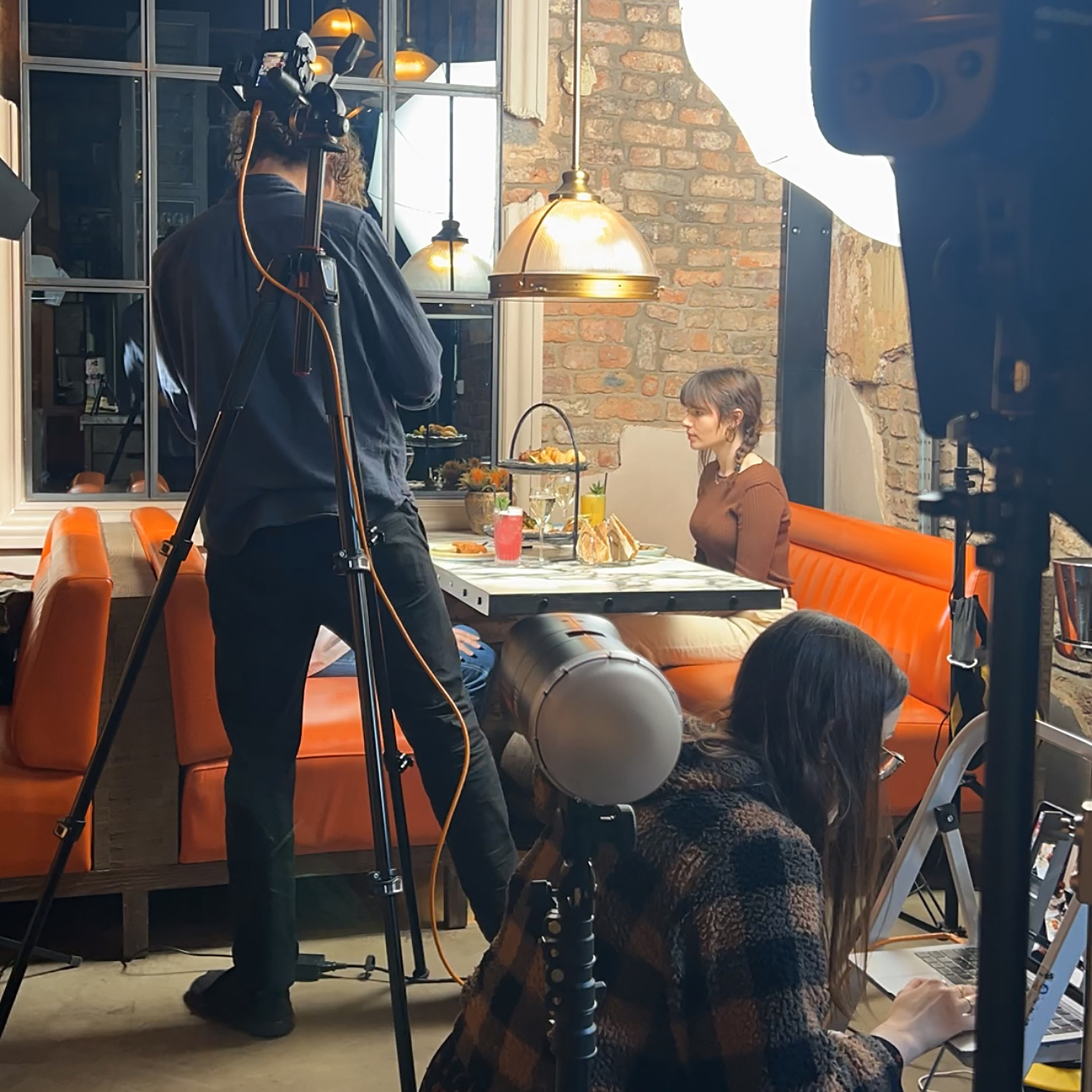 Photographer Georgie Glass with Food Stylist Daisy Hogg and Videographer Sean McCrossan working behind the scenes at a restaurant photoshoot.