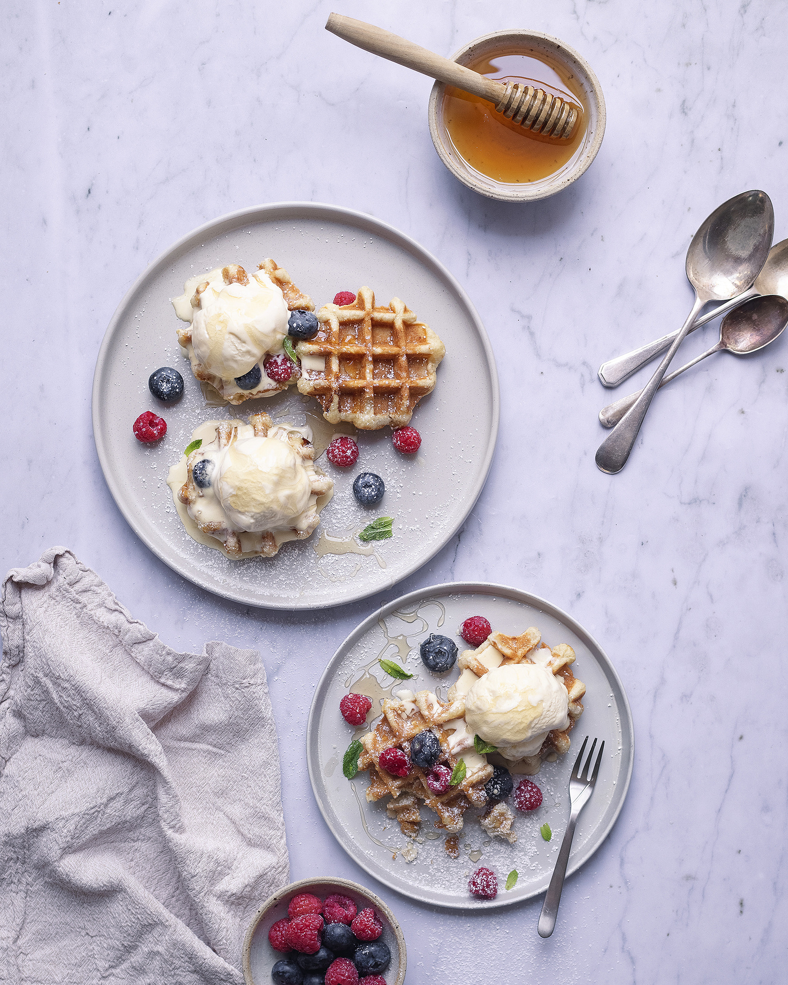 Photograph of 2 plates with waffles, ice cream and honey. Photo by Manchester photographer, Georgie Glass.