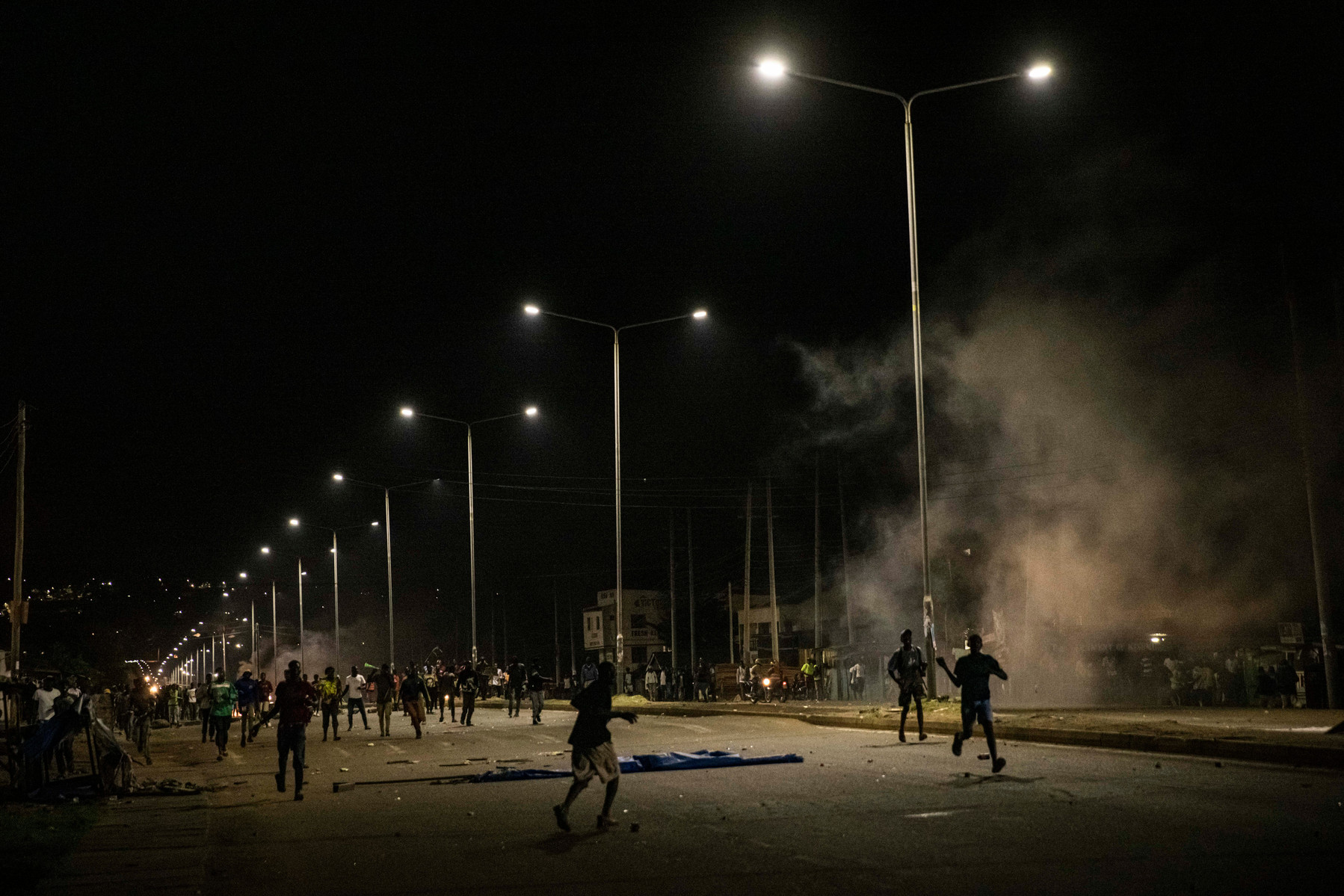 KISUMU, KENYA - AUGUST 15: People protest amid tear gas fired by Kenyan police after election results were announced on August 15, 2022 in Kisumu, Kenya. Some protesters could be heard shouting “No Raila, no peace” as they threw stones and looted shops in