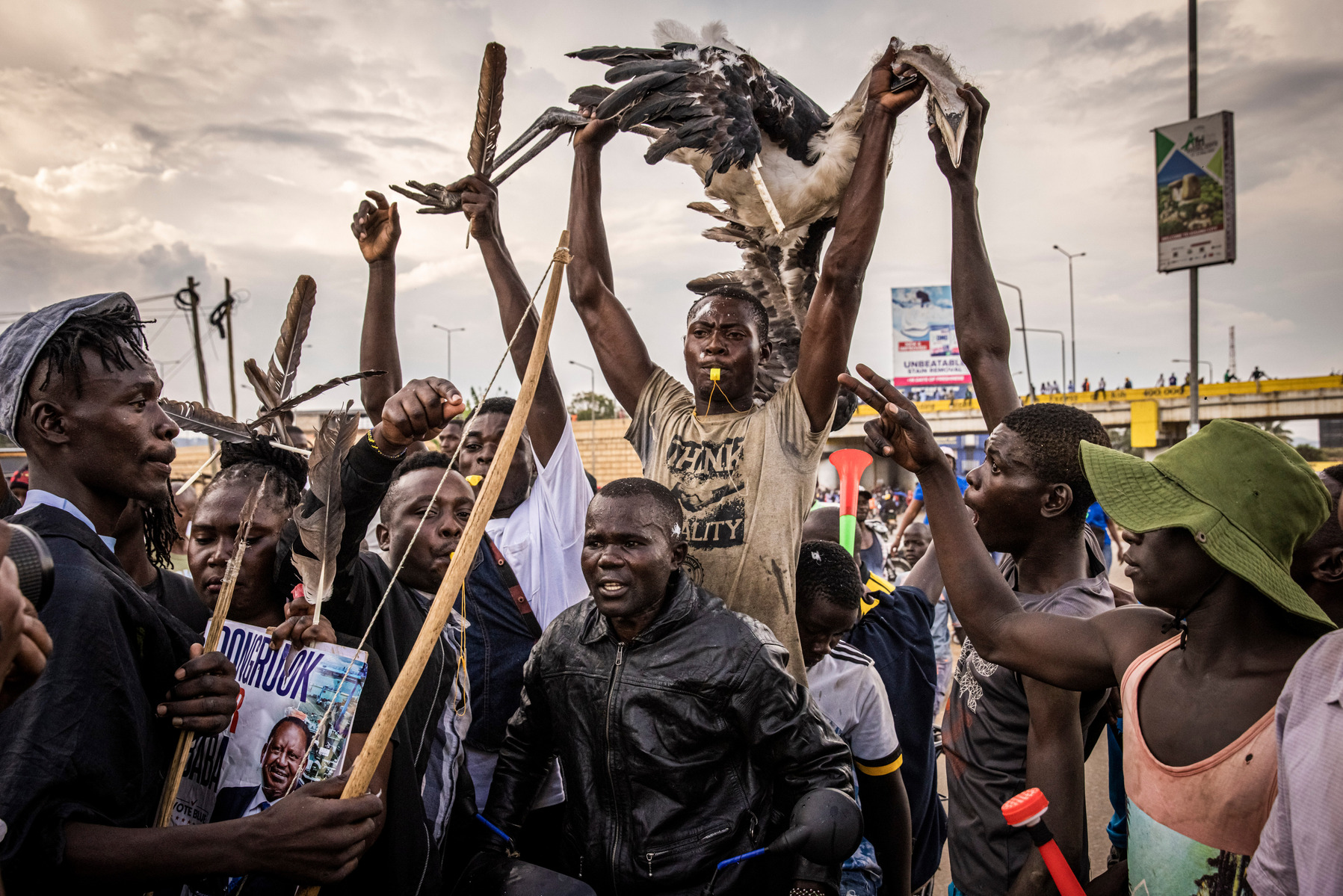 KISUMU, KENYA - AUGUST 15: Men carry a Marabou stork as people protest after election results were announced on August 15, 2022 in Kisumu, Kenya. Some protesters could be heard shouting “No Raila, no peace” as they threw stones and looted shops in one of